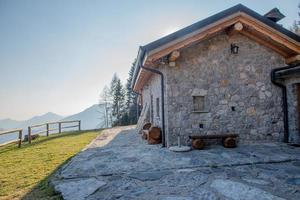 pequeña casa de piedra con jardín en las montañas foto