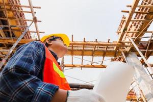 ingeniero, trabajador, hombre, tenencia, plano, control, y, planeamiento, proyecto, en, sitio de construcción foto