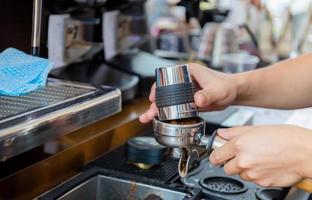 primer plano de la mano del barista haciendo café en la máquina foto