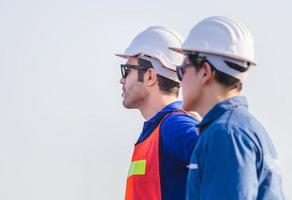 Factory worker man team in hard hat and looking at sky with joy, Happiness and teamwork concept photo