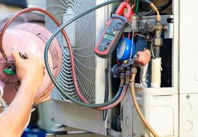 Air Conditioning Repair man checking and fixing modern air conditioning system, Technician team checking leakage air conditioning system photo