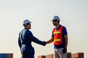 Engineer and worker man handshake on cargo container, Success and teamwork concepts photo