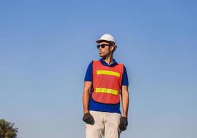 hombre trabajador de fábrica de pie en la caja del contenedor y mirando al cielo foto