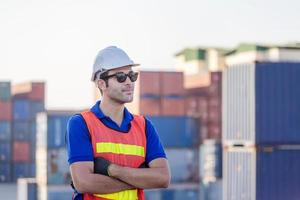 Cheerful factory worker man in hard hat smiling with arms crossed as sign of Success photo