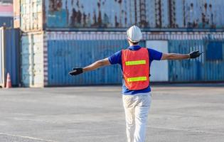 relajante joven con los brazos abiertos después de trabajar, feliz ingeniero capataz en casco y chaleco de seguridad foto