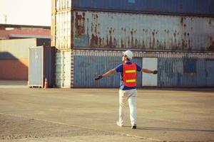 relajante joven con los brazos abiertos después de trabajar, feliz ingeniero capataz en casco y chaleco de seguridad foto