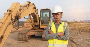 Senior engineer with portable radio transmitter on excavator background photo