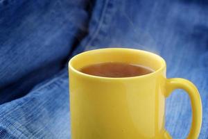 taza amarilla con té caliente foto