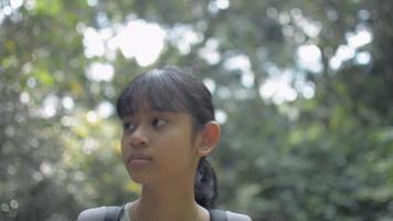 Pretty teenage girl with backpack walking alone in tropical forest during summer. video