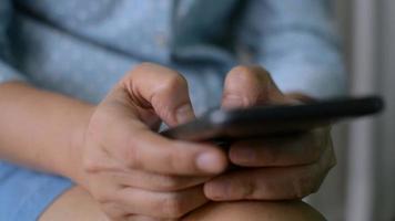 Closeup woman hands texting message on mobile smartphone while sitting at home. video