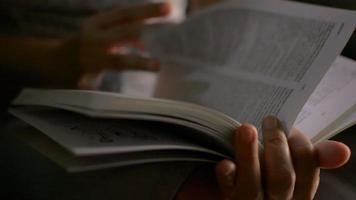 Close up woman's hands holding and turning pages of a book.