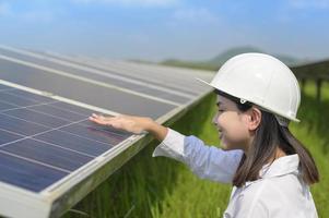 ingeniera con casco en granja de células fotovoltaicas o campo de paneles solares, energía ecológica y limpia. foto