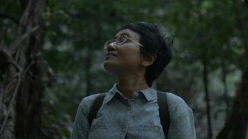 turista feminina asiática de retrato está procurando direção e caminho para sair da floresta. video