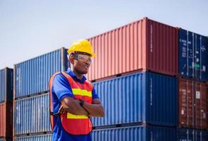 trabajador de fábrica alegre hombre con sombrero duro sonriendo con los brazos cruzados como señal de éxito foto