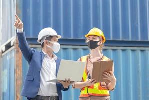 Female engineer and factory worker team checking containers box from cargo, Logistic and teamwork concept photo