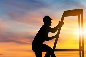 Silhouette of Worker with clipping path go up climbing the ladder evening sunset sky photo