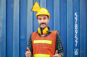 ingeniero alegre con sombrero duro sonriendo con los pulgares hacia arriba como señal de éxito foto