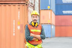 Cheerful engineer man in hard hat smiling with arms crossed and looking at camera photo