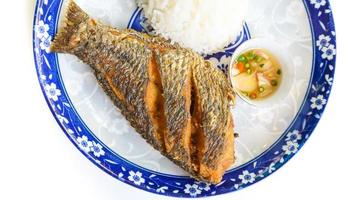 pescado de tilapia frito servido con arroz jazmín y salsa de pescado con chile tailandés, phrik nam pla. foto