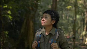 Portrait of female hiker with backpack admire to see beautiful environment in the rainforest. video