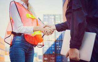 Engineer and worker handshake with blurred containers cargo background, Success and Teamwork concept photo