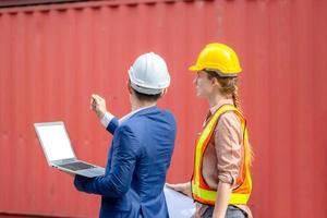 Engineer team with laptop and clipboard checklist checking containers box from cargo, Logistic and teamwork concept photo