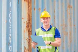 Cheerful engineer man in hard hat smiling and looking at camera with holding clipboard checklist photo