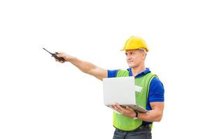 Factory worker in hardhat and safety vest holding two-way radio and laptop, Engineer man with clipping path on white background photo