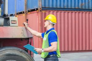 Mechanics checking wheel in cargo container. Professional technician pre-check forklift truck tires, safety concept photo