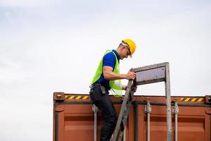 Factory worker man go up climbing the ladder to the container photo