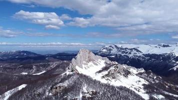 Luftdrohnenansicht des schwer zugänglichen Berggipfels für Kletterer an einem sonnigen Wintertag. Alpinismus und Kletterer. blauer Himmel und weiße leuchtende Farben. filmische Aufnahme. mehr Abenteuer im Leben. video