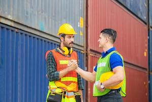 Engineer and worker soul brother handshake, thumb clasp handshake or homie handshake with blurred containers cargo background, Success and Teamwork concept photo