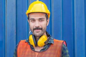 trabajador de fábrica alegre hombre con sombrero duro sonriendo y mirando a la cámara con alegría, concepto de felicidad foto