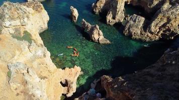Aerial drone shot of kayaks and boats passing around magical Ponta da Piedade limestone cliffs. Exploring caves and tunnels of Lagos, Algarve, South of Portugal. Travel and adventure. Nomad life. video