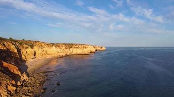 flygdrönare syn på människor på stranden under en vacker solnedgång. fantastiska livfulla färger. algarve, portugal. klart vatten. helgdagar och semestrar. resor och äventyr. nomadliv. video