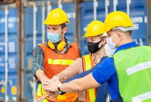 Engineer and factory worker team joining hands at containers cargo, Success Teamwork Concept photo