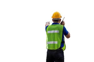 Factory worker in hard hat and safety vest talks on two-way radio, man with clipping path on white background photo