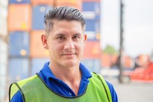 Portrait of happy man at cargo container, Cheerful factory worker smiling and looking at camera with joy, Happiness concept photo