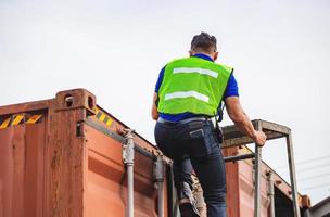 Worker go up climbing the ladder to the container photo