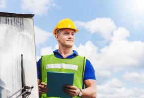Worker man in hardhat and safety vest standing on container stackers control loading containers box from cargo photo