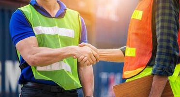 Close up of engineer and foreman worker handshake with blurred construction site, Success and Teamwork concept photo