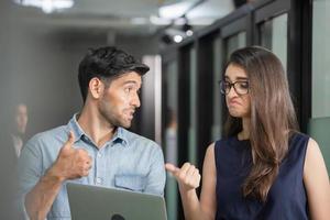 un hombre de negocios que sostiene una laptop y camina discute el trabajo con un equipo femenino, un joven equipo de negocios de compañeros de trabajo reunidos en una oficina creativa foto