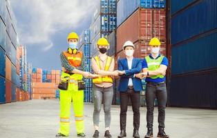 Success Connection and Teamwork Concept, Business people engineer and worker team wearing protection face mask against coronavirus, meeting holding hands together in line photo