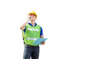 Factory worker in hardhat and safety vest talks on two-way radio, man with clipping path on white background photo