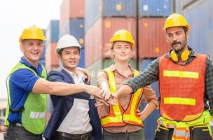 Happiness engineer and worker team group joining hands at cargo containers. Success Teamwork Concepts photo