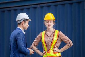 Cheerful engineer and worker team checking containers box, foreman in hardhat and safety vest at cargo photo