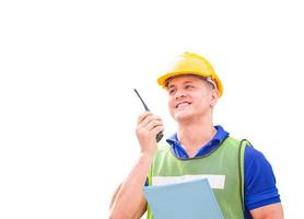 Factory worker in hardhat and safety vest talks on a two-way radio, Foreman with clipping path on white background photo