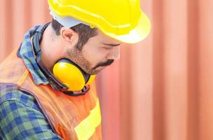 Close up of Worker man in hardhat and safety vest, Engineer checking containers box from cargo photo