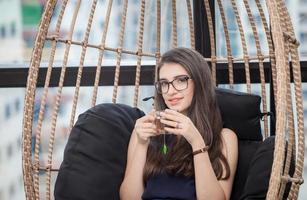 joven mujer de negocios relajándose con una taza de té en la oficina moderna