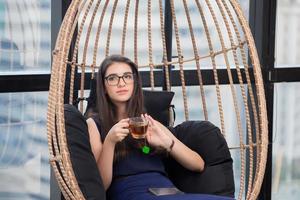 joven mujer de negocios relajándose con una taza de té en la oficina moderna